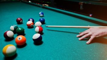 Hand man holding billiard cue to shoot balls